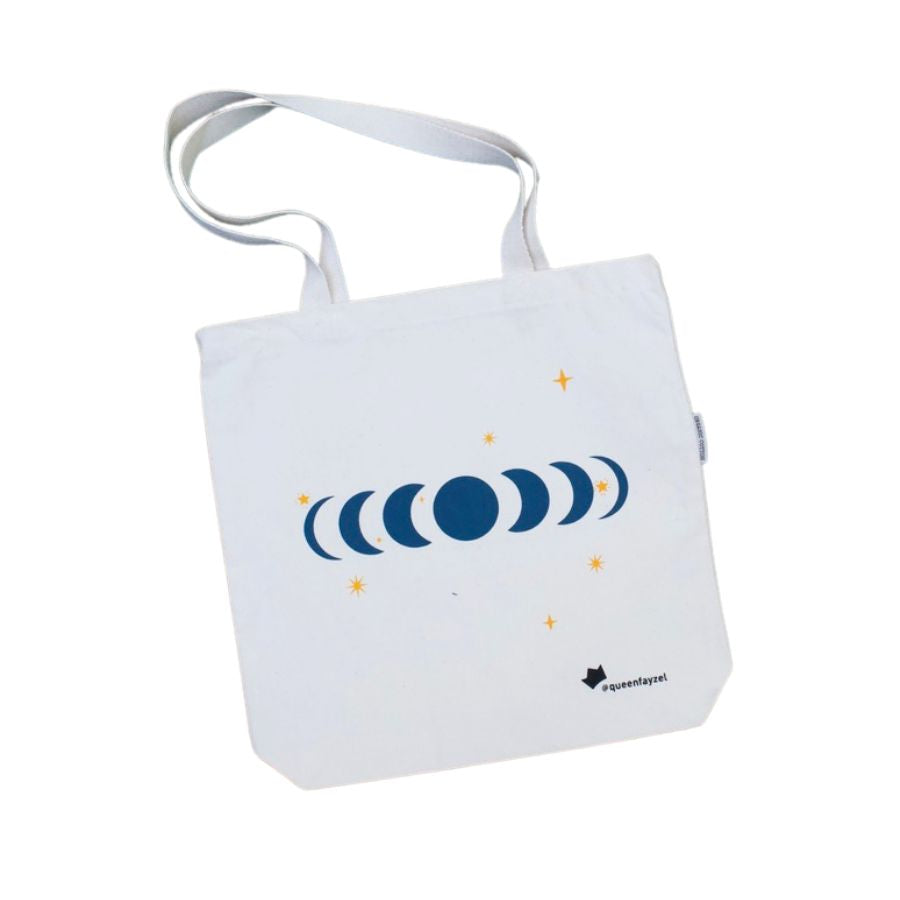canvas tote bag with moon phases design and star accents, against a white background