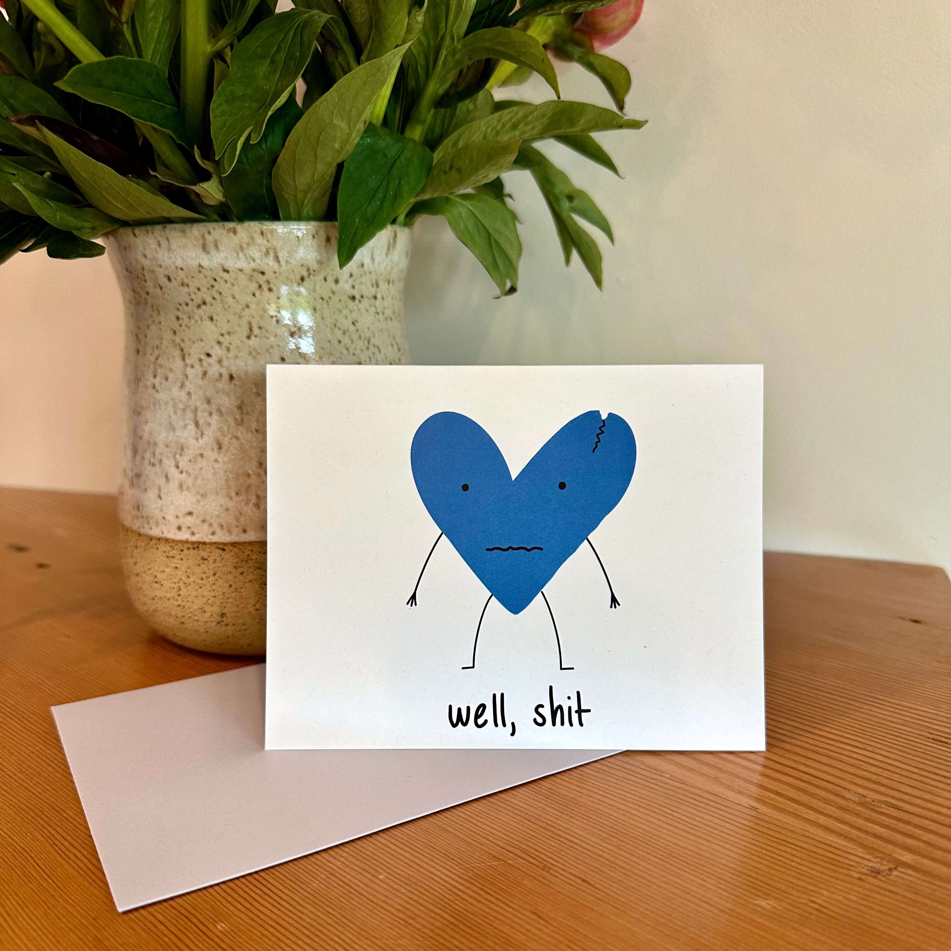 condolence card with a beat-up blue heart and the words, "well, shit"