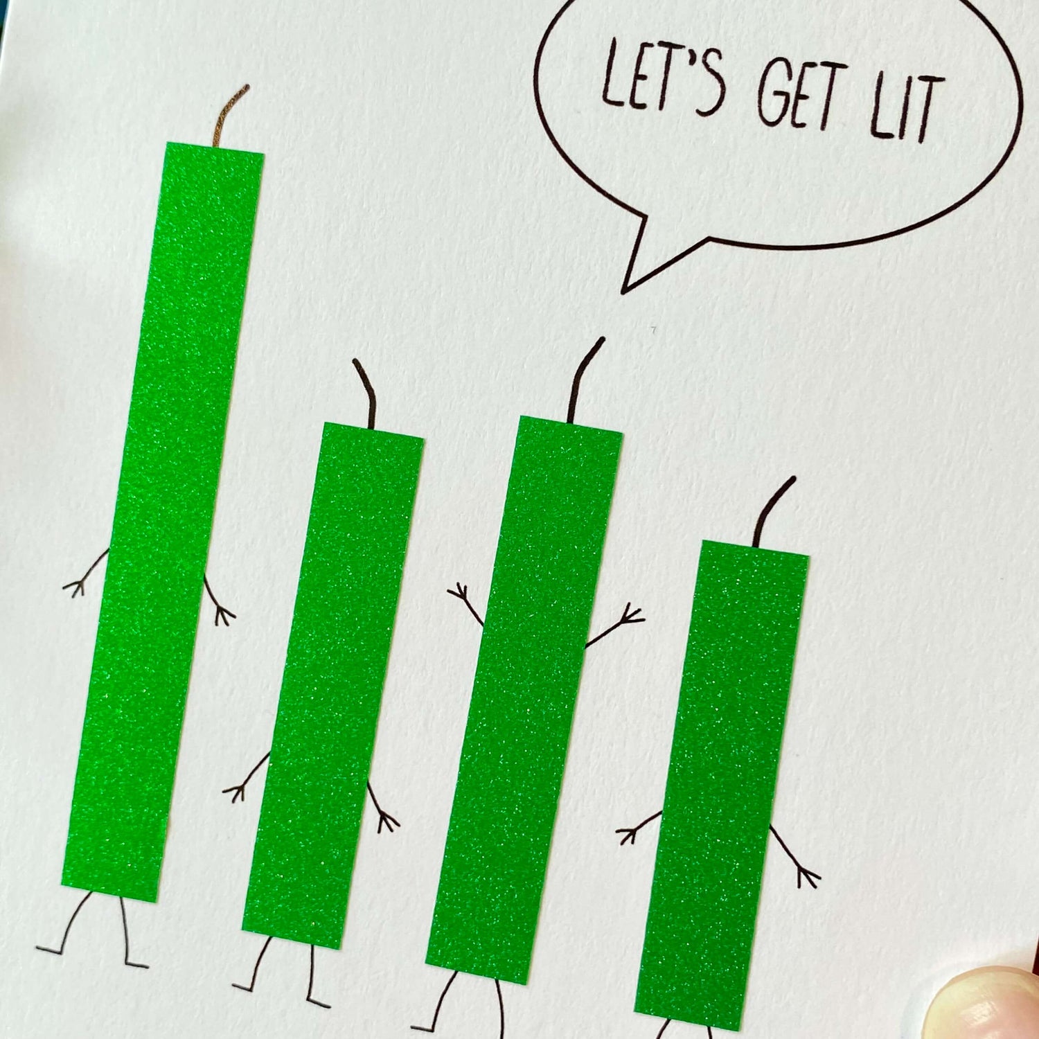 Close up of green glitter candles on a birthday card that says, "Let&