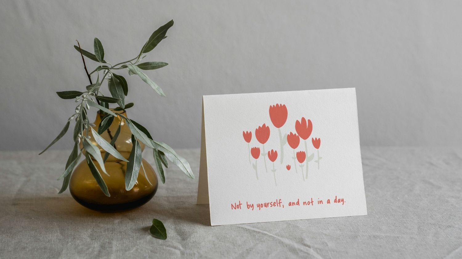 Sympathy card propped next to a small vase with eucalyptus branches