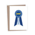 A white congratulations greeting card with a blue prize ribbon featuring the word &