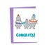 A white greeting card with a purple envelope behind it, featuring three cartoon hippos wearing party hats and holding signs that say &