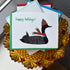 Greeting card with a loon illustration wearing a hat and scarf, labeled &