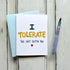 A funny anniversary card in a light blue envelope featuring "I TOLERATE THE SHIT OUTTA YOU" in playful blue and yellow fonts with a red heart.