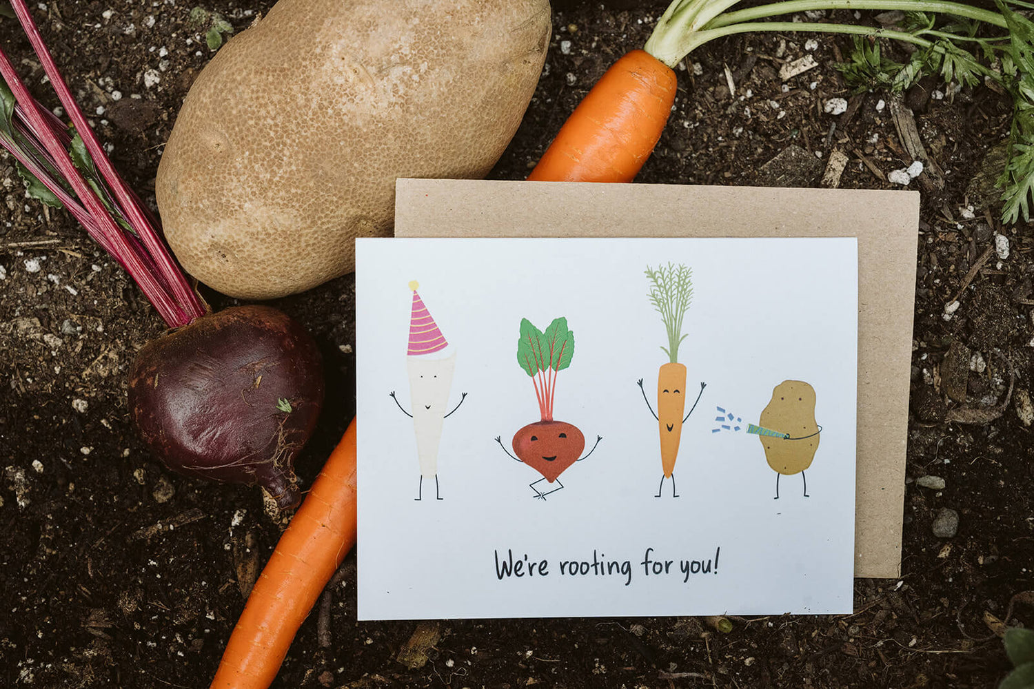 encouragement greeting card with four cheering root vegetables and the text, "We're rooting for you"