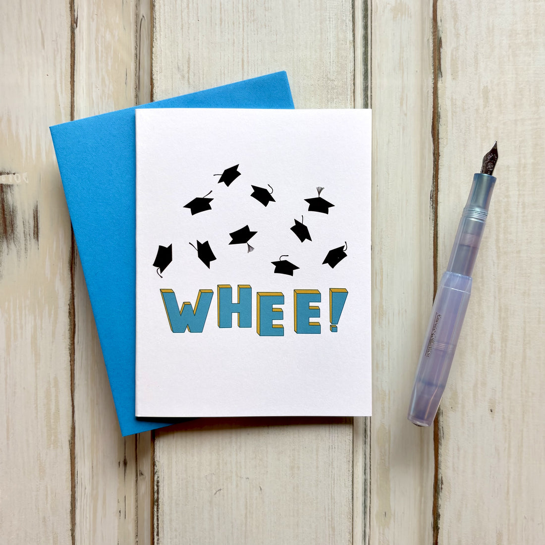 Graduation congratulations card featuring scattered graduation caps in flight and playful "WHEE!" lettering in vibrant blue.