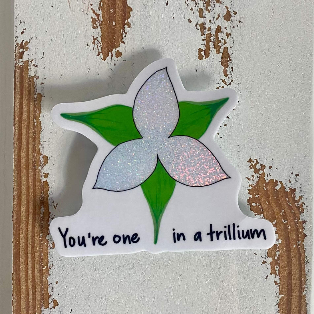 A vinyl sticker with a sparkly trillium flower design and the phrase &