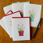 Greeting cards with red and blue heart plants, and a black pen.