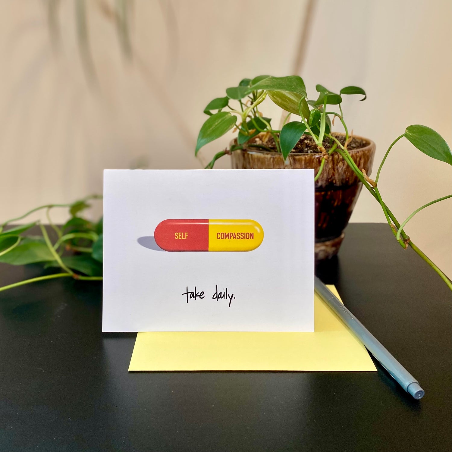 Greeting card with red and yellow self compassion pill and the text, "take daily."