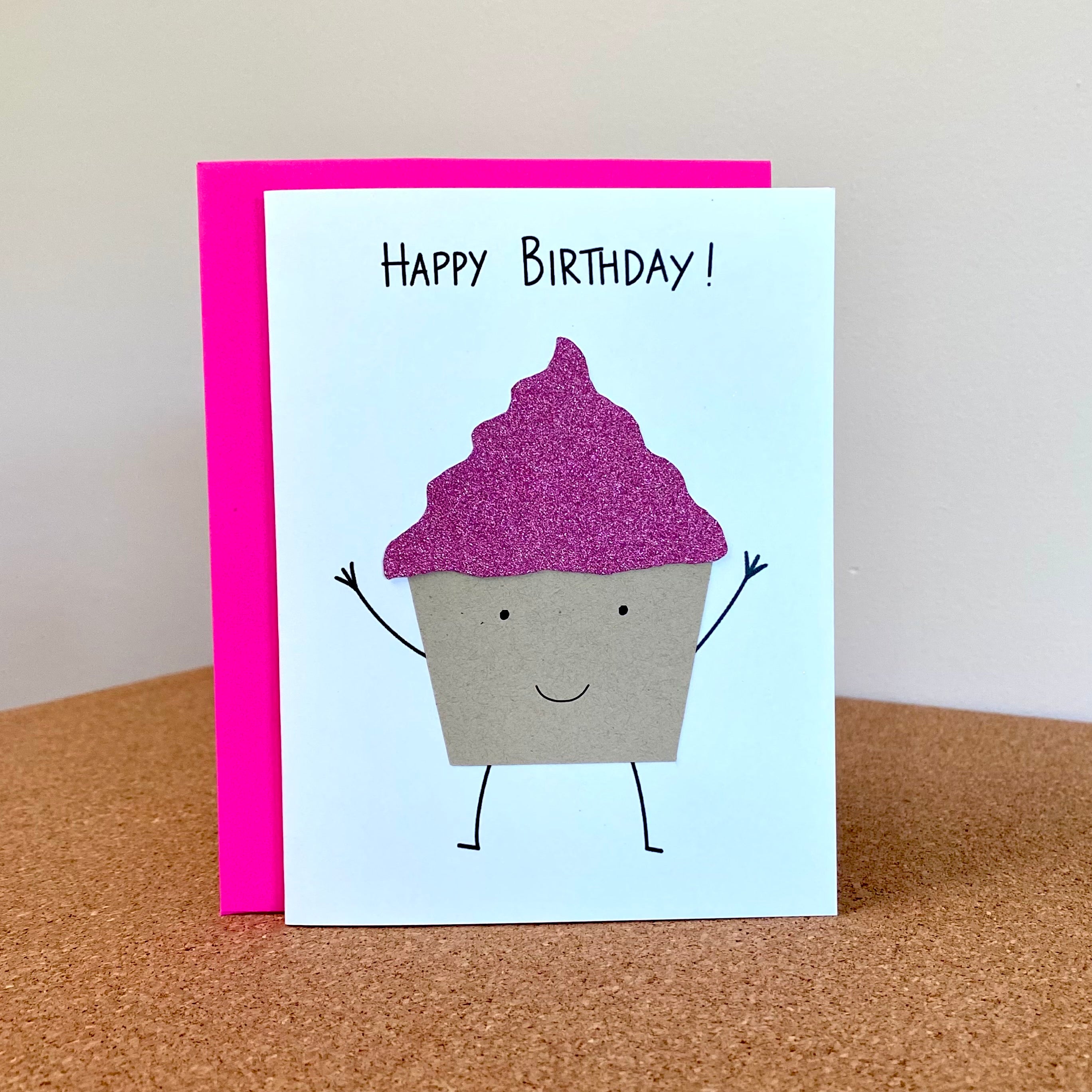 Birthday card with smiling cupcake with pink glitter frosting.