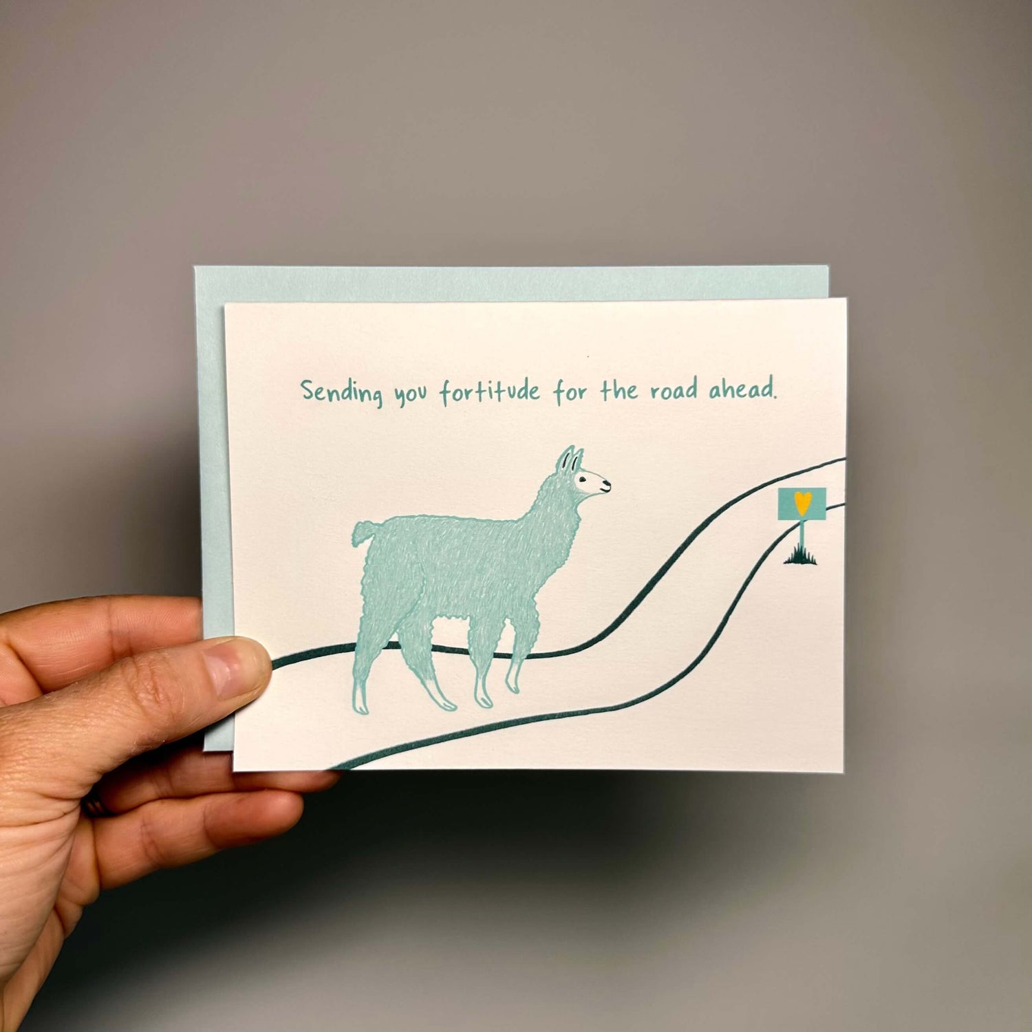 Card with a llama walking down the road and the text "Sending you fortitude for the road ahead."